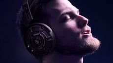 A man with a beard listening to Yamaha YH-4000 headphones with a happy expression on his face