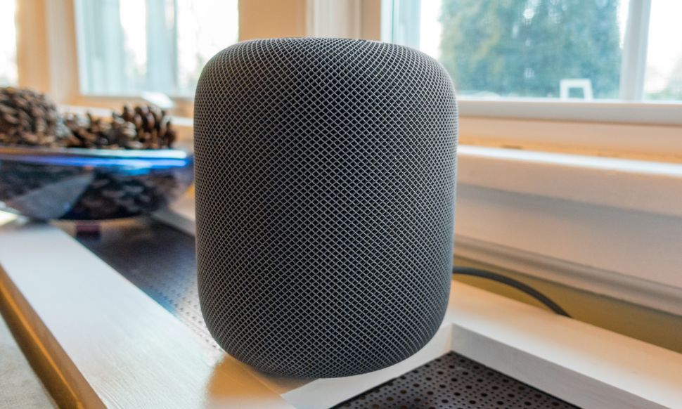 The Apple HomePod mini on a shelf next to a window