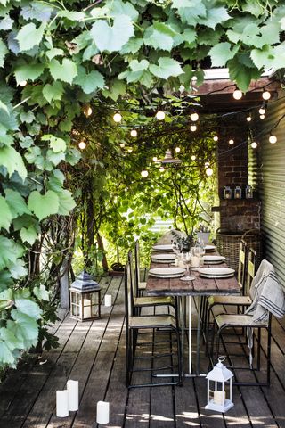 Modern garden ideas: dining area with festoon lights hanging overhead