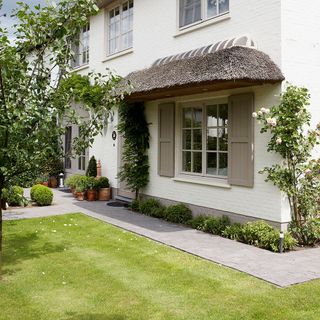 exterior of house with green grass and potted plant