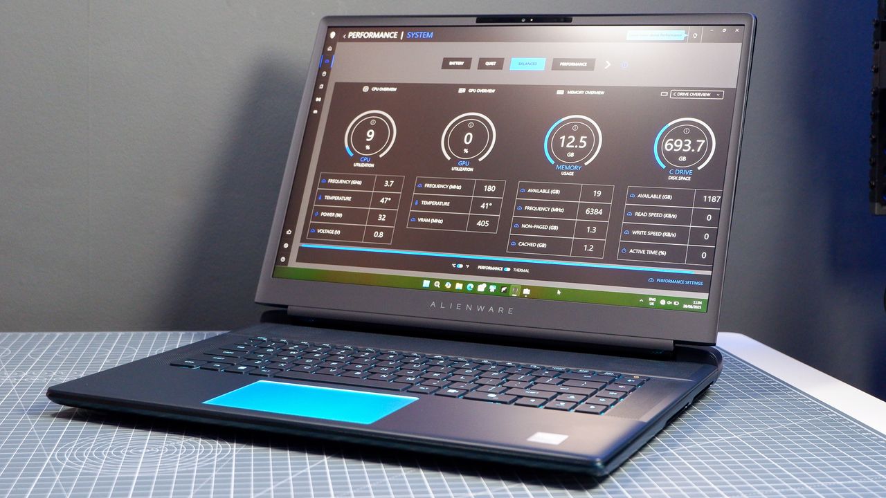 An Alienware 16 Area-51 gaming laptop with RGB lighting in blue on a desk mat.
