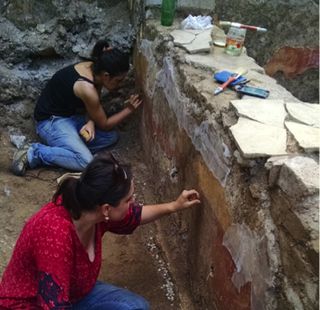 This photo shows researchers working on some of the wall paintings from the building.