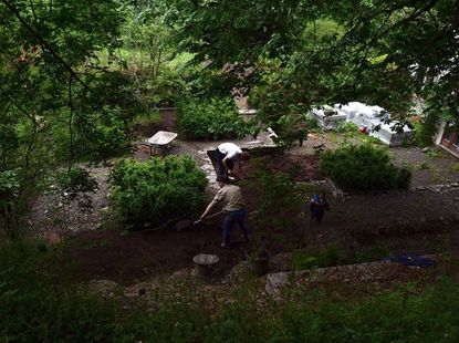 An aerial shot showing Harry and David Rich working with gardening tools in their garden in Wales