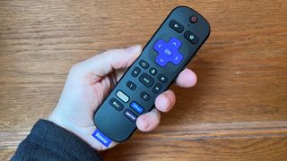 Roku Plus Series TV remote control held in hand