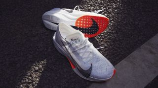 Nike Vaporfly NEXT% 3 running shoes on Tarmac, one shoe is on its side to show the outsole