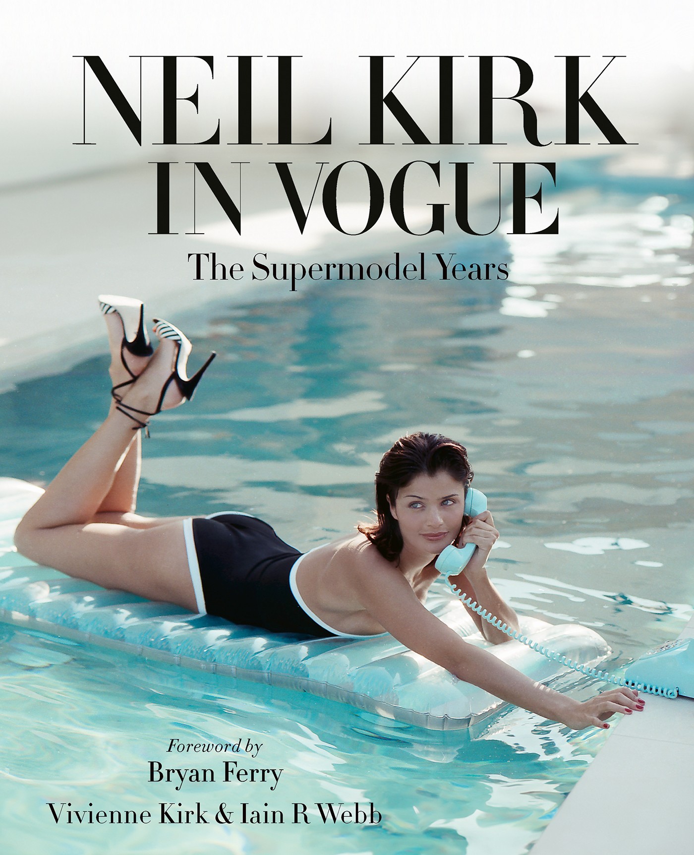 Neil Kirk in Vogue: The Supermodel Years book cover: A model lies on a pool lilo in a black swimsuit and striped heels, phone to her ear, legs kicked up behind her