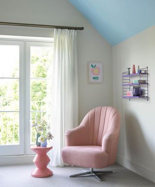 bedroom with light blue ceiling and pink chair