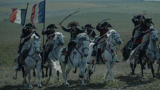 A still from Ridley Scott's Napoleon film, with horses charging into battle.