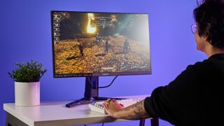 A person playing Clair Obscur: Expedition 33 on a Lenovo Legion R27qe Gen 2 gaming monitor