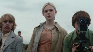 Ryan Lee, Elle Fanning and Joel Courtney standing together during a film shoot in Super 8.
