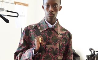 Model wears patterned jacket and gold ring at Valentino S/S 2019