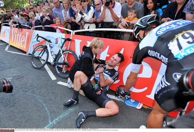 Mark Cavendish holds his shoulder after his crash