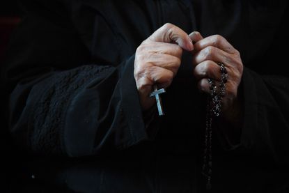 A Catholic worshipper holds a cross