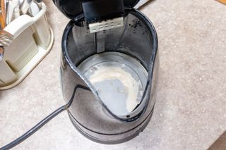 An open kettle with limescale in the bottom