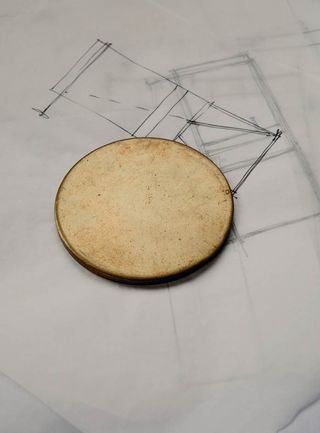 A round object placed on a white paper with a sketch