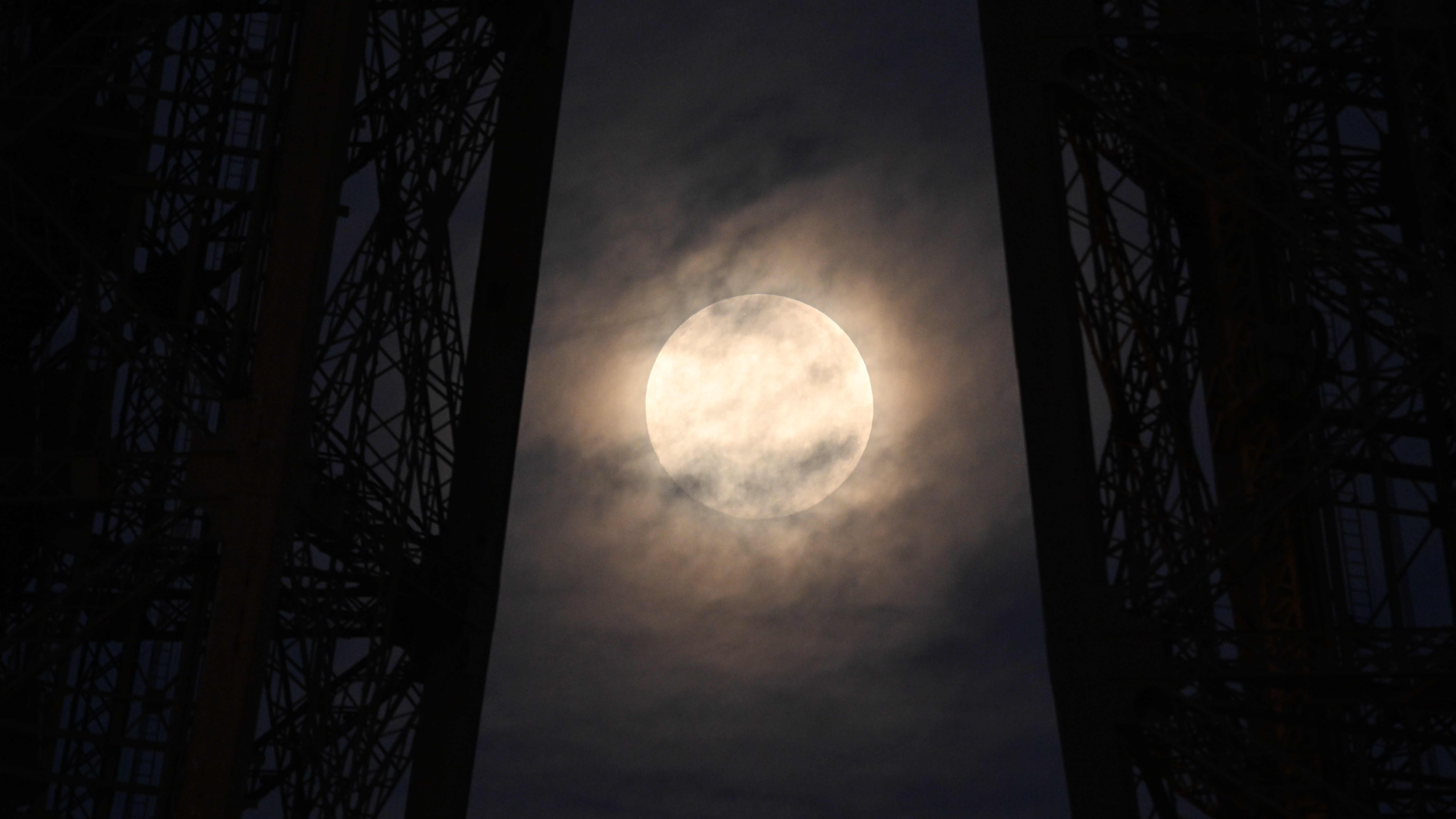 A photo of the &quot;Cold Supermoon&quot; behind the Eiffel Tower in Paris. 