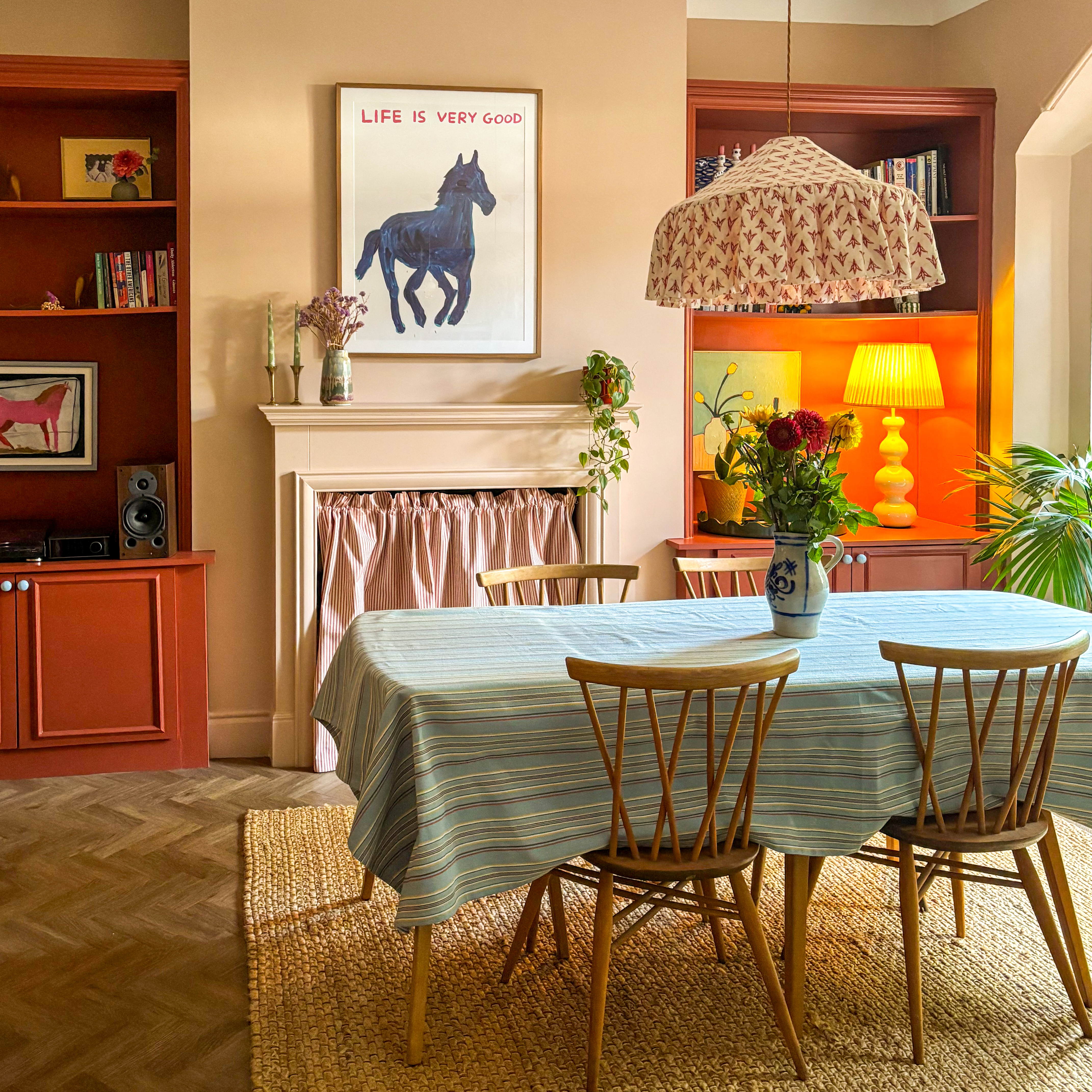 dining room with pink walls and red joinery