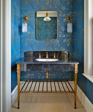 Powder room with blue wallpaper and vanity