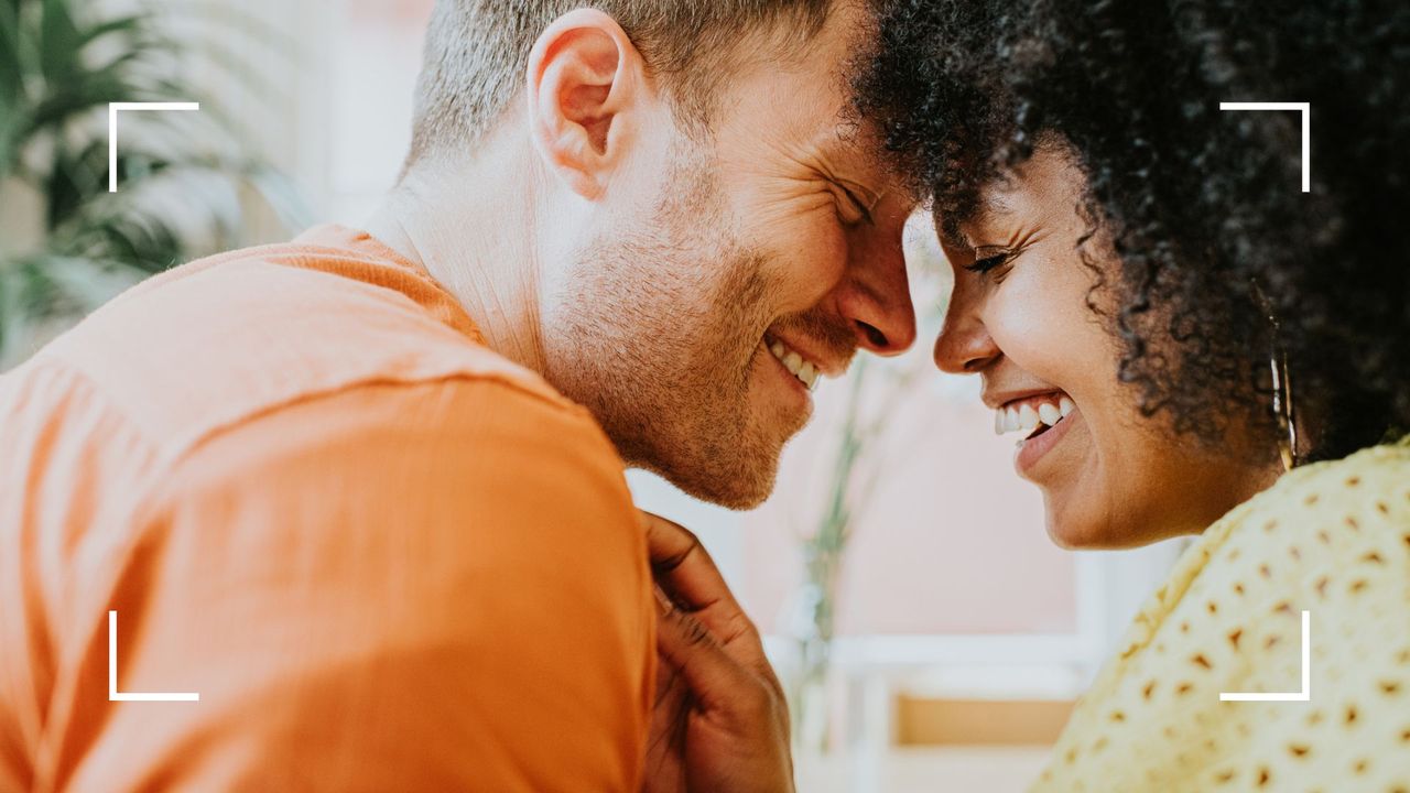 Couple face to face, smiling and laughing, being romantic to represent the lotus sex position