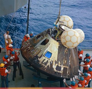 After the successful splashdown of the Apollo 13 command module and the three astronauts on board, crew from the USS Iwo Jima hoisted the spacecraft out of the water.