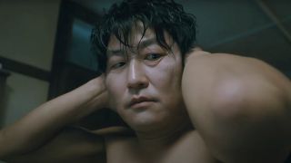 Fr. Sang-hyun shirtless with hands behind his head in Park Chan-wook's Thirst