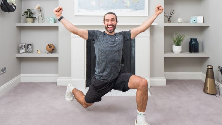 Joe Wicks also known as The Body Coach stretches in his home