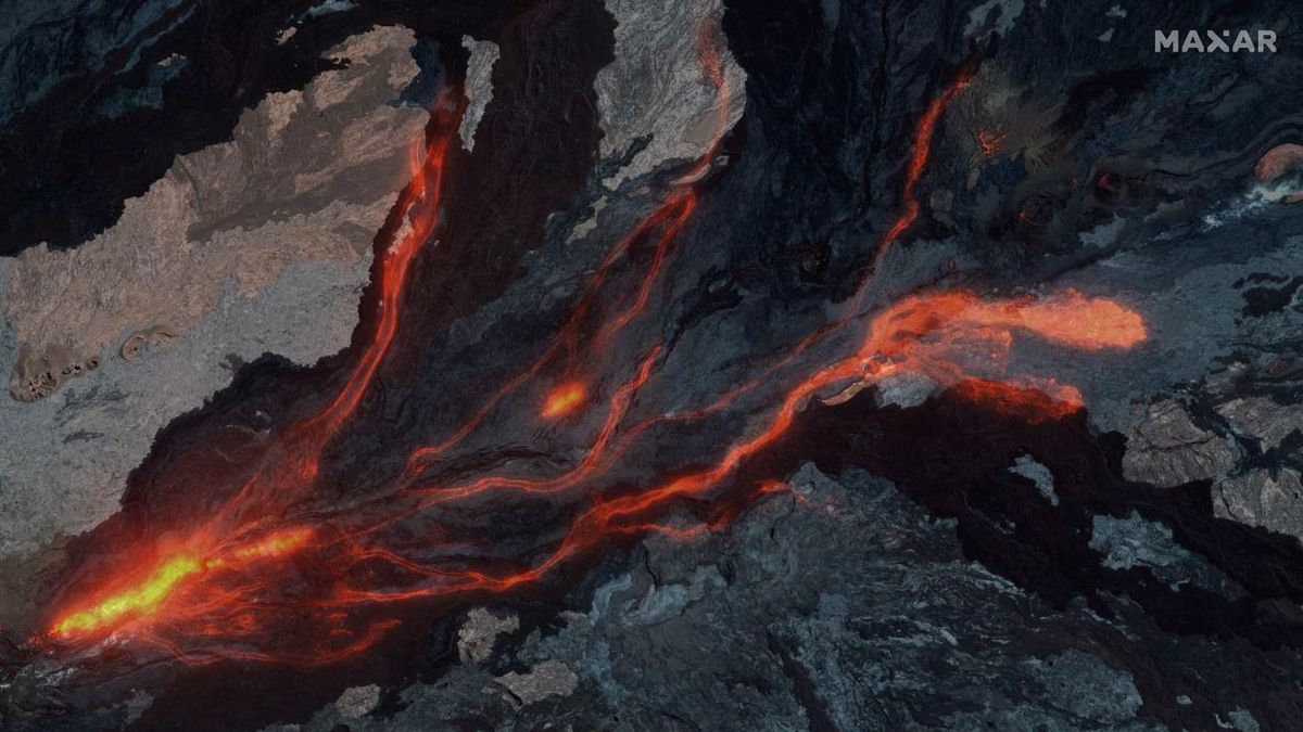 A composite view overlays Maxar's nighttime view of Mauna Loa's lava on Nov. 28, 2022, atop an older image of the volcano before the eruption began.
