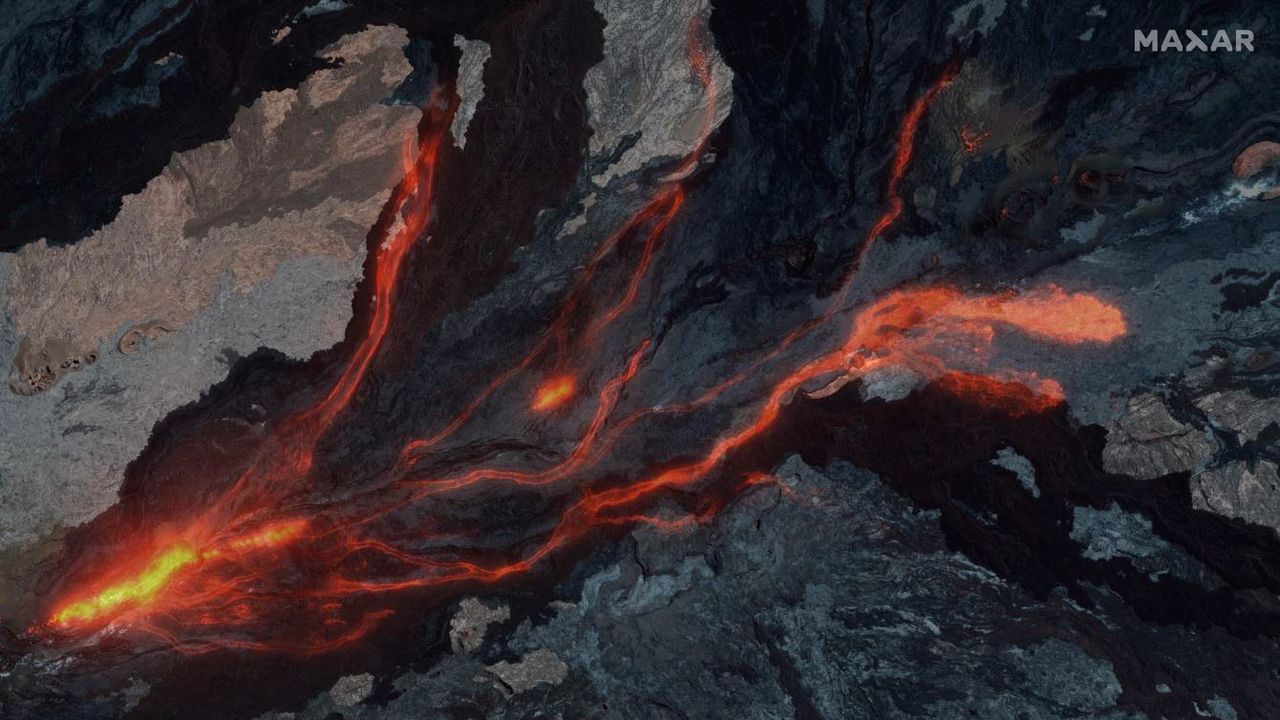 A composite view overlays Maxar's nighttime view of Mauna Loa's lava on Nov. 28, 2022, atop an older image of the volcano before the eruption began.