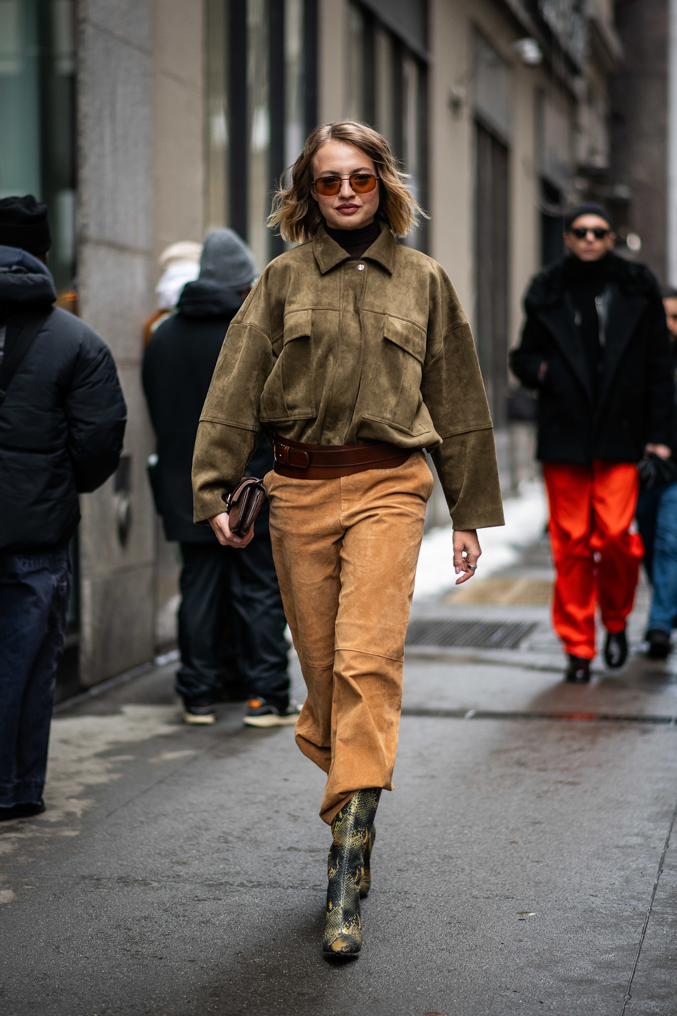 new york fashion week fall 2026 attendee wears olive suede jacket, suede pants, and snakeskin boots