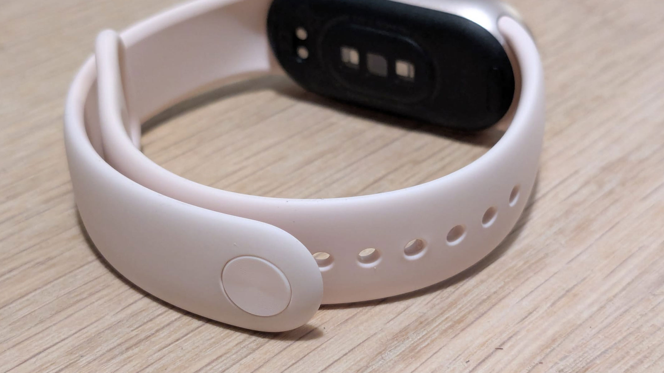 A close-up of the strap design of the Xiaomi Smart Band 10, showing a light pink strap.