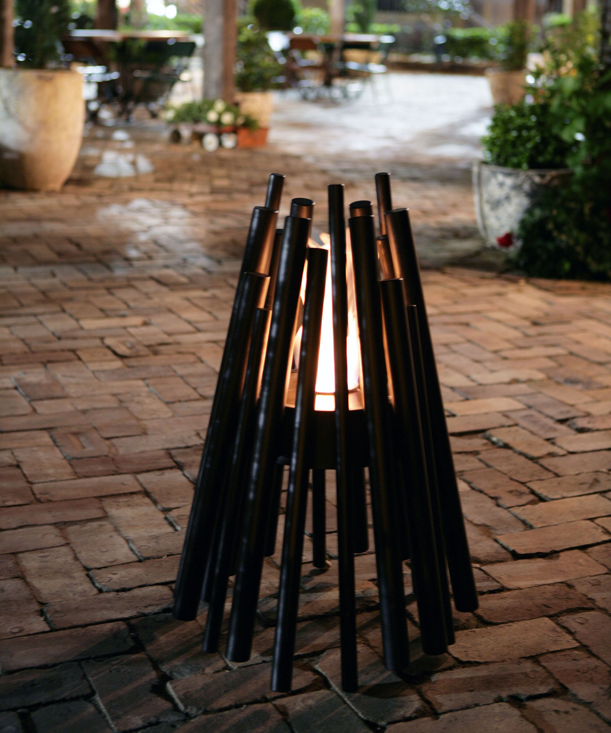Campfire style fire pit on paved area to the back of a house
