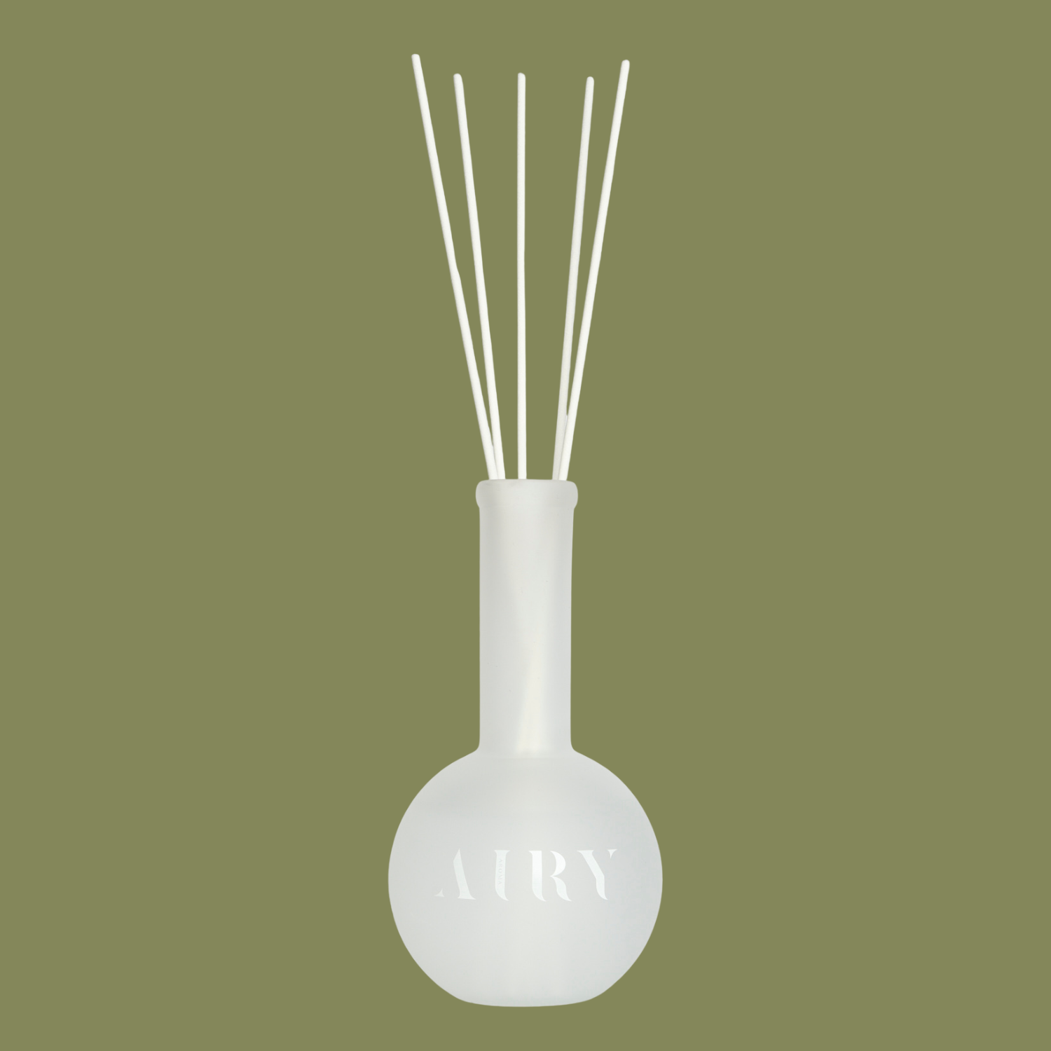 A frosted glass reed diffuser against a navy green background