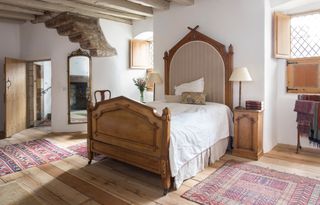 antique wooden bed in beamed bedroom