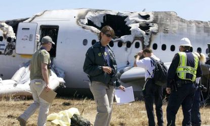 An NTSB investigator examines scattered debris on the scene of the Asiana Airlines crash.