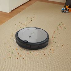 robot vacuum cleaner cleaning up mess on beige carpet