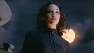 Jessica Alba looking out as she stands in front of the moon in Dark Angel.