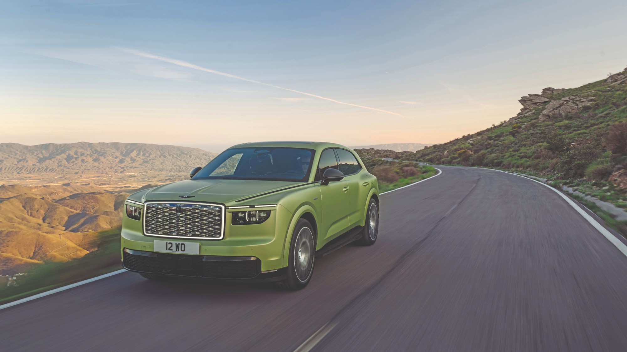 Green Bentley Torcal driving at sunset