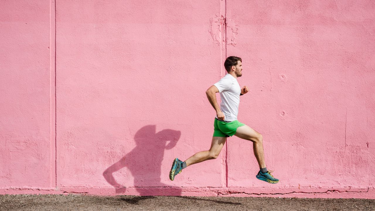 the best running shoes: runner in running shoes against pink wall