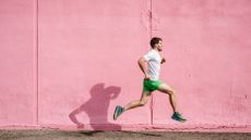 the best running shoes: runner in running shoes against pink wall