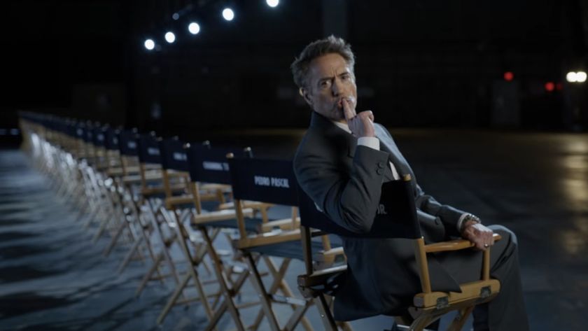 Robert Downey Jr. performing the shush gesture with a line of chairs behind him in Marvel's Avengers: Doomsday cast announcement video