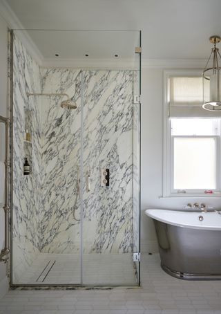 marble shower enclosure with downlights and silver bath
