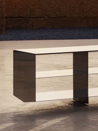 A sideboard comprises a black chrome aluminium frame and bronze-mirrored glass top