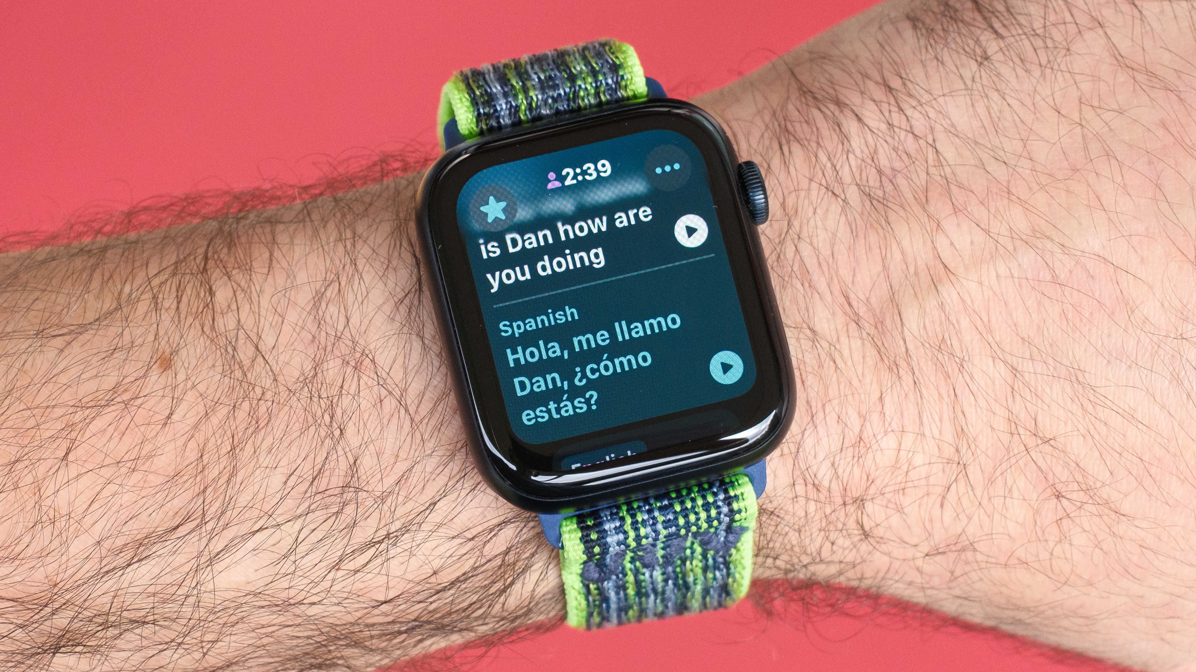 Close-up of an Apple Watch SE 2022 against a red background with the new Translate app on the screen