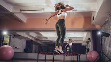 Woman doing rebounding exercise on mini trampoline in studio