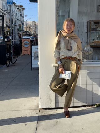 Irene Chen wearing an Irish fisherman sweater with a tan sweater around her shoulders.