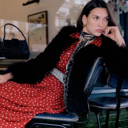 rixo model wearing black fur coat and red and white polka dot dress