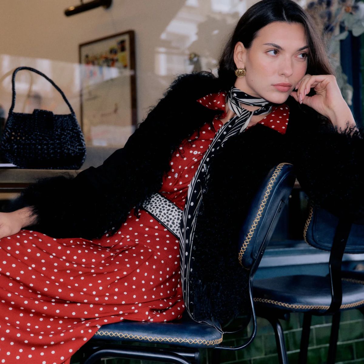 rixo model wearing black fur coat and red and white polka dot dress