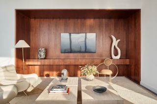 A cream colored rug sits under cream colored tables and accent chairs