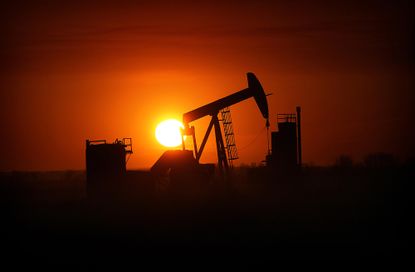 The sun sets behind a North Dakota drilling rig.