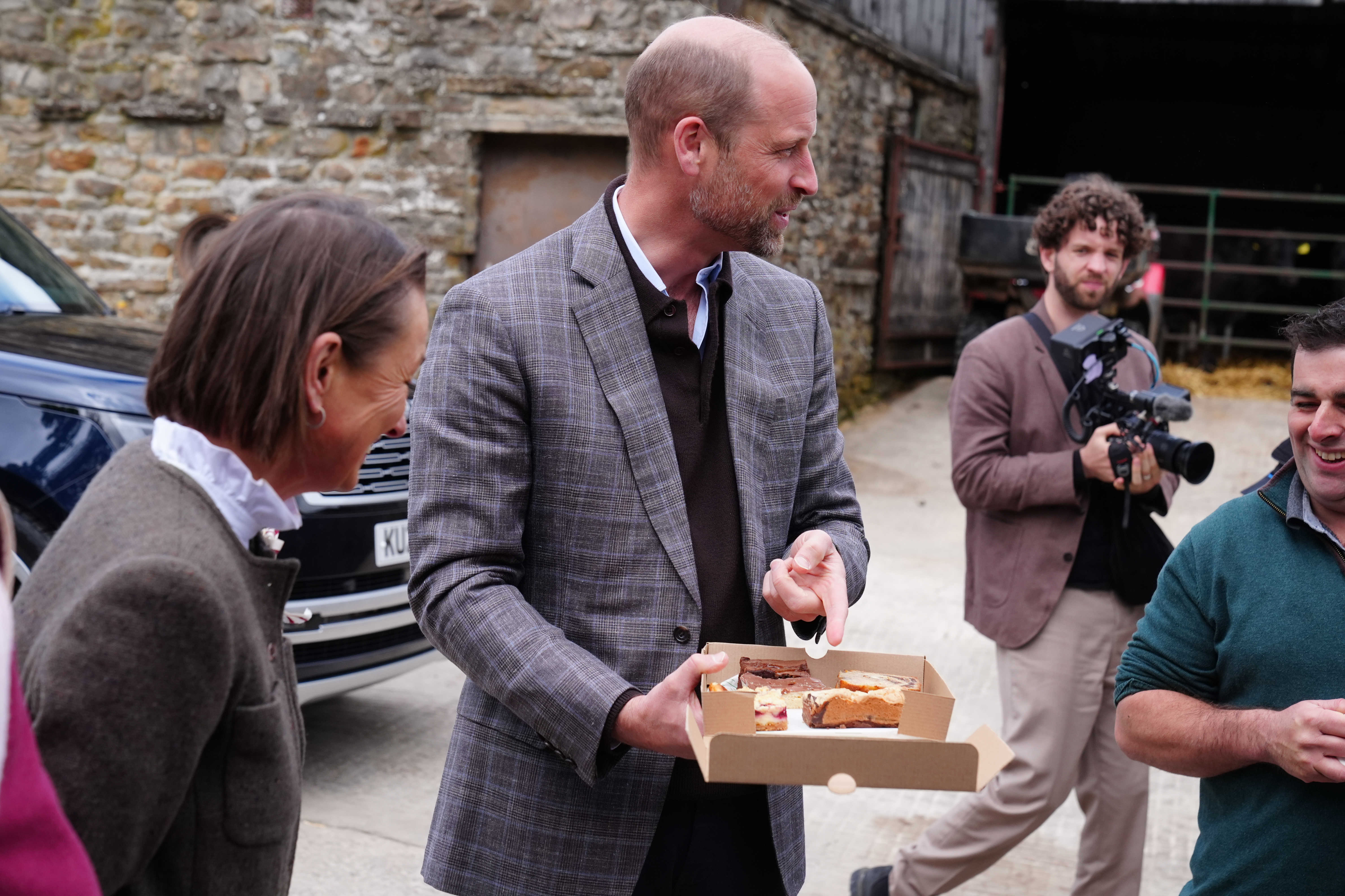 Prince William holding a box of cake